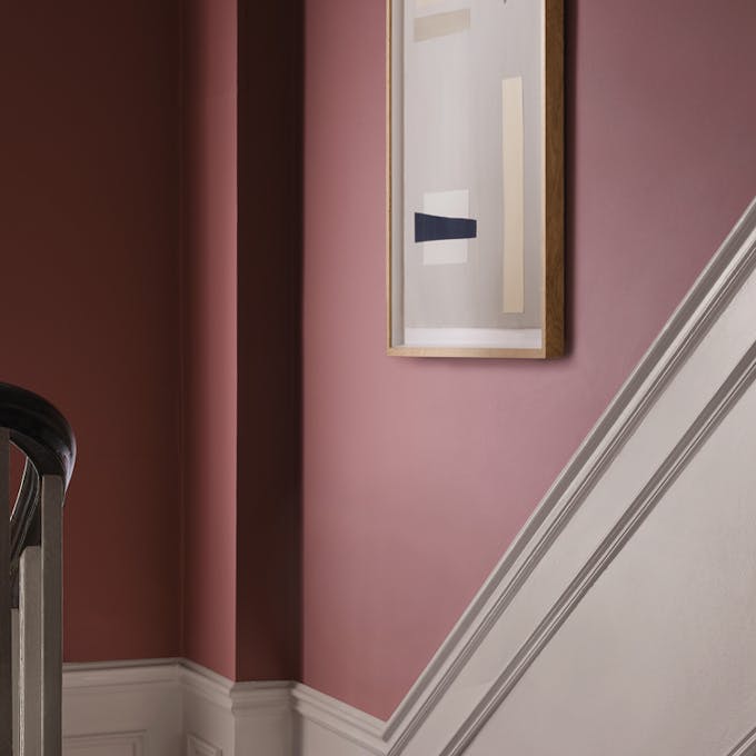 close-up view from the top of the stairs, with walls painted in Soumak red with a pale neutral beneath the dado rail